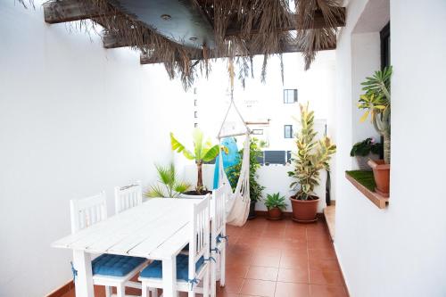 a white table and chairs in a room with plants at SURF DREAM House in Corralejo