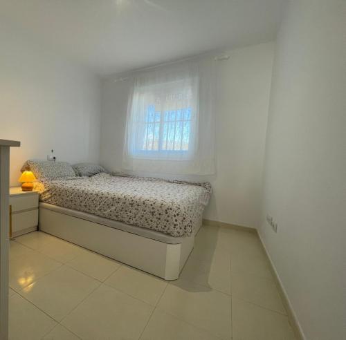 łóżko w białym pokoju z oknem w obiekcie La Terraza del Gallopedro w mieście Vera