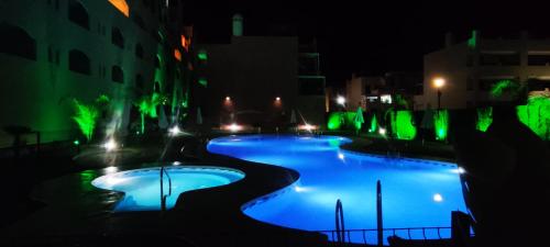 einen Pool in der Nacht mit grüner Beleuchtung in der Unterkunft La Terraza del Gallopedro in Vera