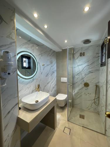 a bathroom with a sink and a shower at Hotel Makkas in Kréntis