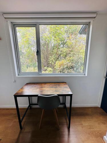 a table with a chair in front of a window at MAKTVB Europa - Hostal Boutique in Santiago