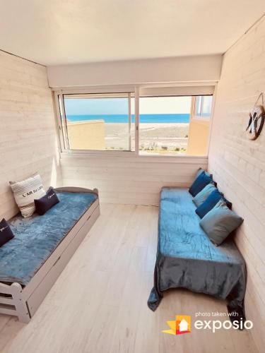 - une chambre avec 2 lits dans une chambre avec une fenêtre dans l'établissement LA CABANE DE LA MER, à Leucate