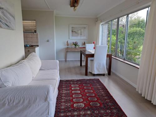 a living room with a white couch and a table and window at Kairos on the Lake in Sedgefield
