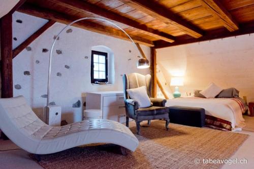 a bedroom with a bed and a desk and a chair at Luxury stay in 250 year old wine farm house and gardens in Rüschlikon