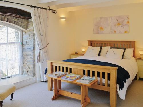 1 dormitorio con cama, mesa y ventana en Shamrock Cottage en Cenarth