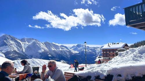 a group of people sitting on top of a snow covered mountain at Trimka in Fiesch