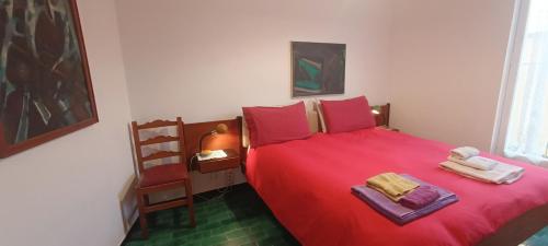 フィナーレ・リーグレにあるCasa di Claude con posto autoのベッドルーム1室(赤いベッド1台、タオル付)