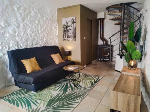 a living room with a blue couch and a staircase at Maison de village avec terrasse in Luc-en-Diois