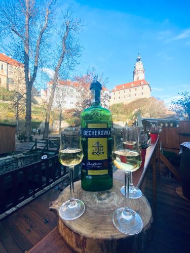 a bottle of wine and two glasses on a table at Kristínka in Český Krumlov