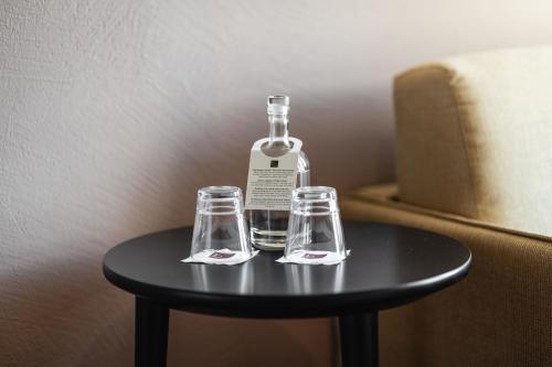 butelka i dwie szklanki siedzące na stole w obiekcie Kloster by b-smart w mieście Schaan