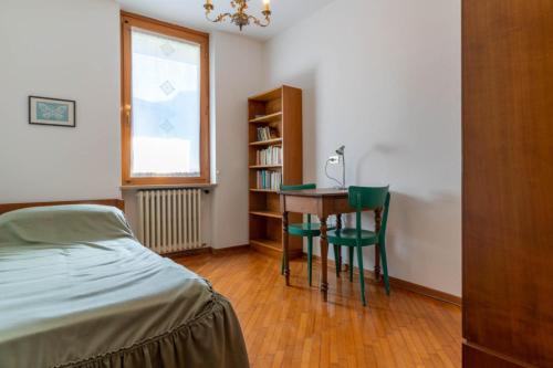 a bedroom with a desk and a bed and a window at Casa Agnese, Levico Terme - Ospitar in Levico Terme