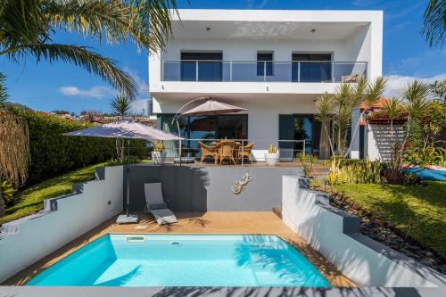 a villa with a swimming pool and a house at Villa Hibiscus by An Island Apart in Calheta