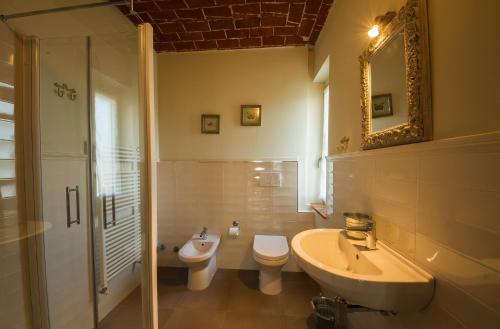 W łazience znajduje się toaleta z umywalką i lustro. w obiekcie La Casa nel Vento w mieście Vignale
