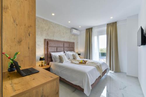 Un dormitorio con una cama y una computadora portátil en un escritorio. en Luxury Villa JoMaNI with heated pool, en Bibinje