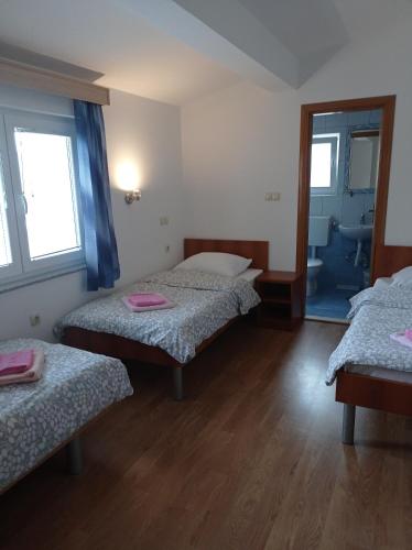 a room with two beds and a bathroom with a mirror at Casa Del Pellegrino M&A - Ostojići in Međugorje
