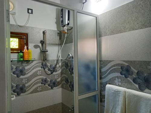 een douche met een glazen deur in de badkamer bij Ayubowan Homestay Katunayake in Katunayaka