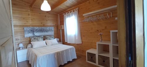 een slaapkamer met een bed in een houten kamer bij Casa La Cabaña in Chiclana de la Frontera