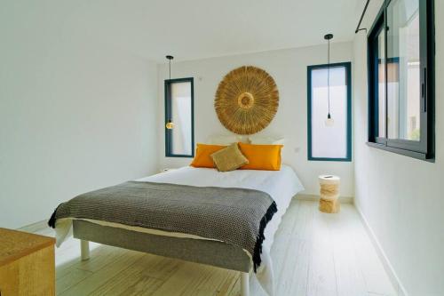 een slaapkamer met een groot bed met oranje kussens bij Maison bohème au bord de l'eau in Sète