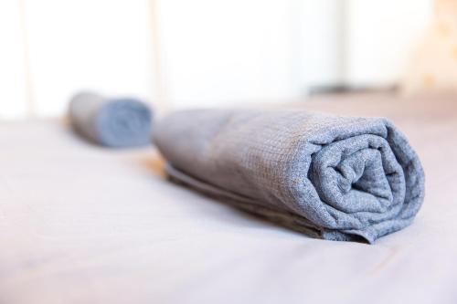 a rolled up towel laying on a bed at Auguste, La Romaine et My César - Location Saverne in Saverne