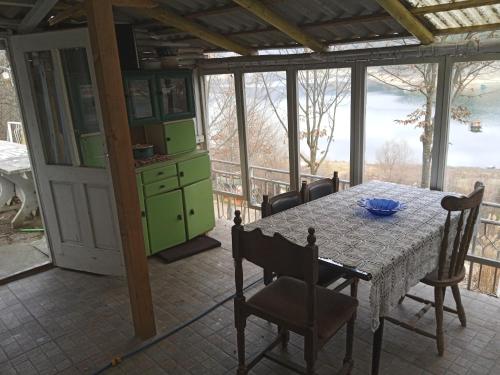 a dining room with a table and chairs and a view at Vikendica Vidikovac na Zavojskom jezeru in Pirot