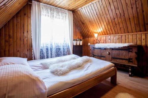 a bedroom with a large bed with a window at Villa Cztery Strony Świata in Zakopane