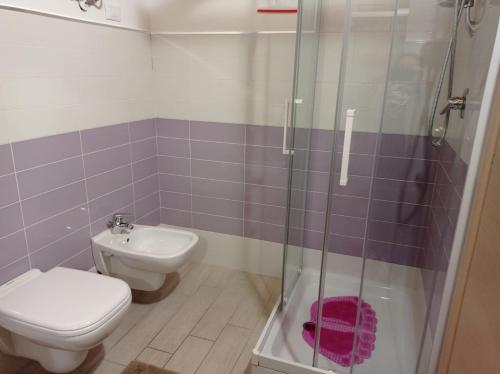 a bathroom with a toilet and a glass shower at Case Vacanza Villaggio Riva Azzurra in Policoro