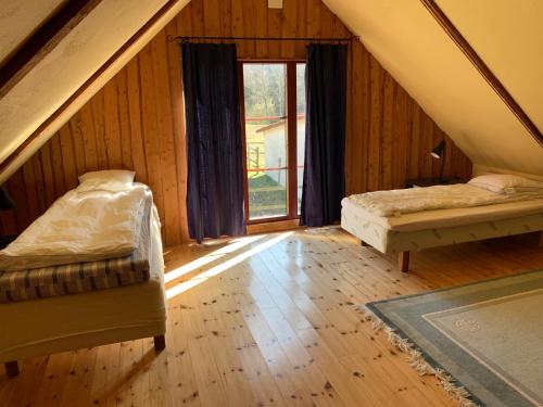 a attic room with two beds and a window at Navröds Gård in Sjöbo