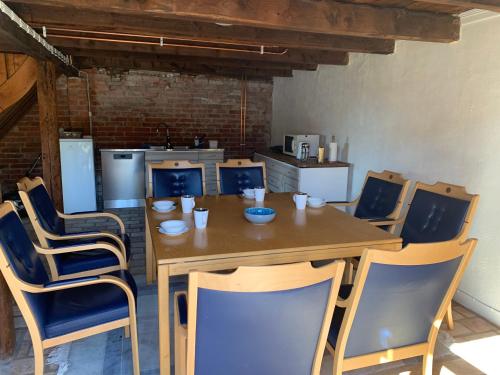 uma sala de jantar com uma mesa de madeira e cadeiras em Navröds Gård em Sjöbo
