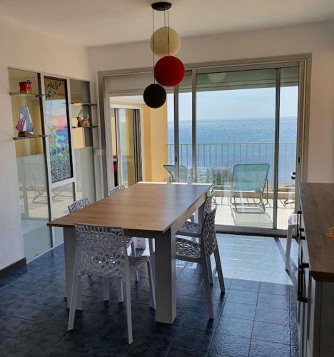 - une table à manger avec des chaises et une vue sur l'océan dans l'établissement Magnifique vue mer La terrasse de Poséidon, au Cap d'Agde