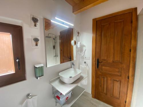 a bathroom with a sink and a wooden door at Casa De Los Silos 