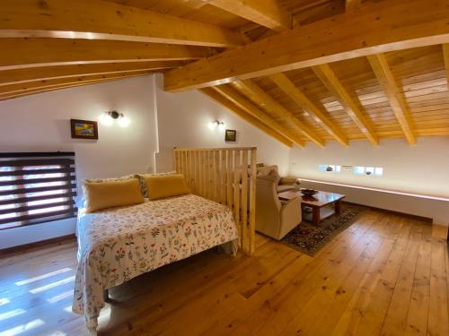 ein Schlafzimmer mit einem Bett in einem Zimmer mit Holzdecken in der Unterkunft Casa De Los Silos 