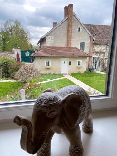 a statue of an elephant sitting on a window sill at Au fil de l’Ô in Bisseuil