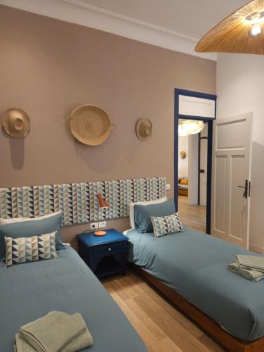 a bedroom with two beds and a table with a hat on the wall at LAU APP VICTOR CENTRE VILLE in Rabat