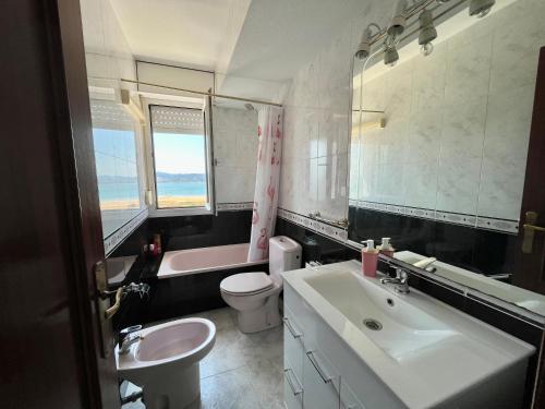 a bathroom with a sink and a toilet and a mirror at Apartamento Libertad in Laredo