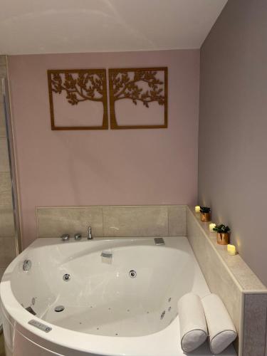 a large white bath tub in a bathroom at Au fil de l’Ô in Bisseuil