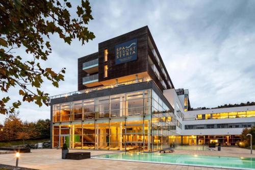 a large building with a pool in front of it at Golf & Relax Apartment mit 4*S-Anbindung in Bad Waltersdorf