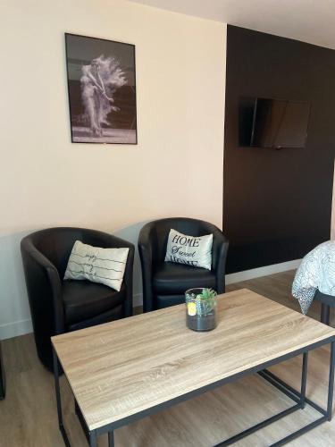 two chairs and a coffee table in a room at Au fil de l’Ô in Bisseuil