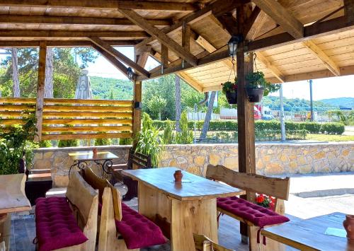 a patio with a table and chairs and a wooden roof at Apartmani Bosfor in Niška Banja