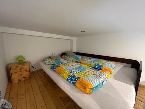 ein Schlafzimmer mit einem Bett mit einer Decke darauf in der Unterkunft Vito Apartman in Eger