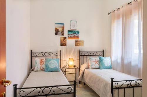 two beds sitting next to each other in a bedroom at Trivano Villasimius in Villasimius