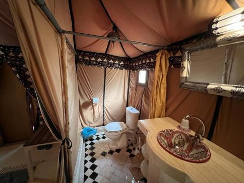 a inside of a tent with a toilet and a sink at Merzouga Luxury Tented Camp in Merzouga