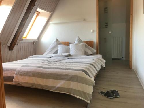 a bedroom with a bed with a pair of shoes on the floor at Hof Seebrookquelle in Schlesen