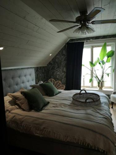 a bedroom with a large bed with a ceiling fan at Mojo organic spa in Borgholm