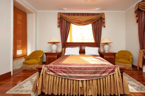 シントラにあるSanta Maria Casa Nostraのベッドルーム1室(ベッド1台、椅子2脚、窓付)