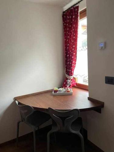 a wooden table with two chairs and a window at La Goille Morgex in Morgex