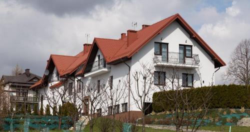 a large white house with a red roof at Zajazd u ELiZY in Czajowice