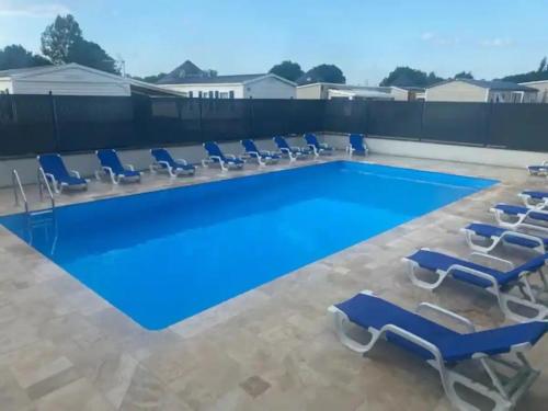 a swimming pool with lounge chairs and a swimming pool at Le Cocooning in Biville-sur-Mer