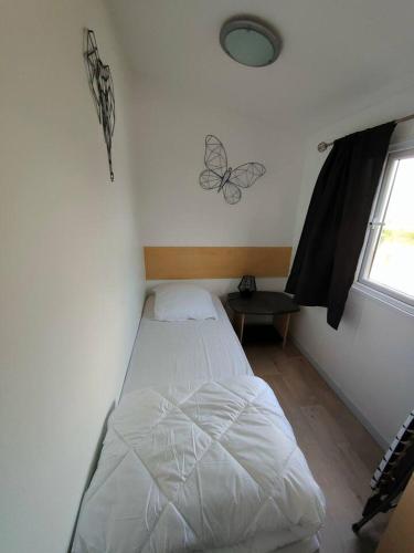 a bedroom with a bed in a room with a window at Le Cocooning in Biville-sur-Mer
