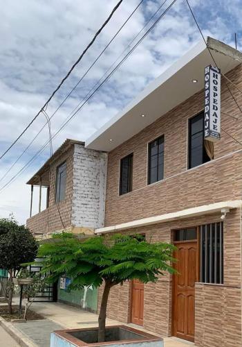 un edificio con un árbol delante en HOSPEDAJE NELLY, en Puerto Chicama