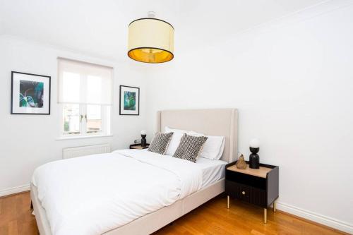 a white bedroom with a white bed and a window at The Art House by Sorted Stay in Woodham Ferrers